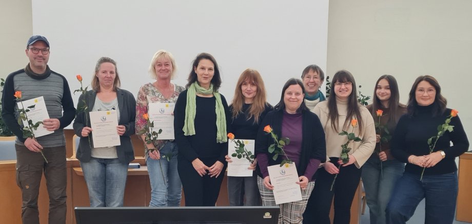Nine educators from the Idar-Oberstein city administration have undergone further training to become language support staff. The photo shows the nine educators and the two speakers after the presentation of the certificates.