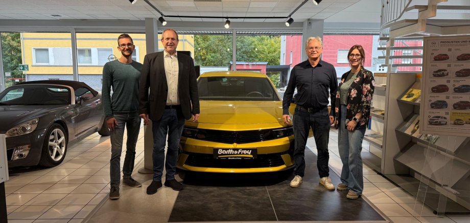 Mayor Frank Frühauf and Caroline Pehlke from the city's business development department visited Michael and Moritz Frey from the Barth and Frey car dealership. The photo shows the company owners Michael and Moritz Frey, Mayor Frühauf and Caroline Pehlke from the business development department next to an Opel vehicle.