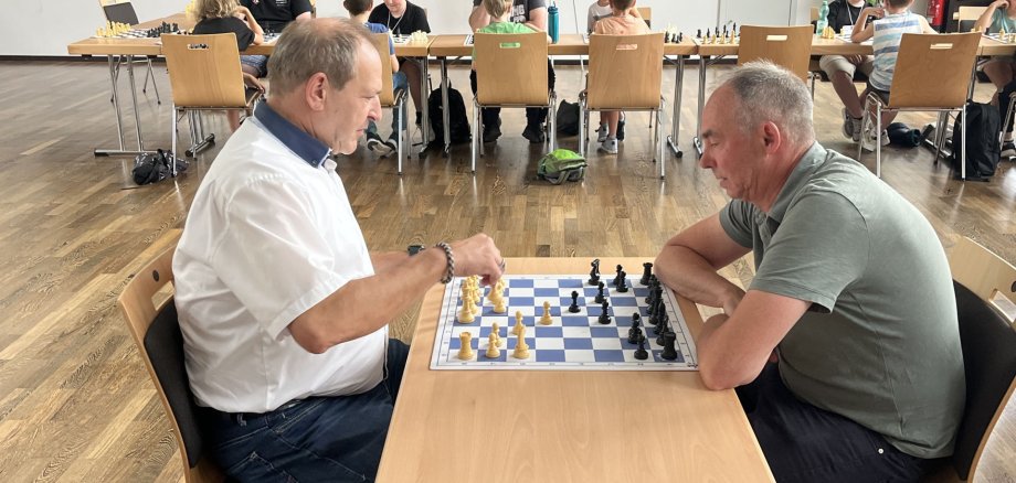 The photo shows Mayor Frank Frühauf and Michael Schweizer, director of the Youth Welfare Office, sitting at a chessboard as part of the summer vacation program.