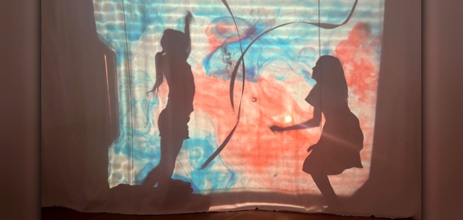 The photo shows two children behind the shadow wall.