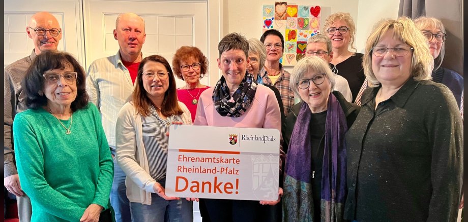 Michael Brill (left) presented volunteer cards from Rhineland-Palatinate to the dedicated end-of-life caregivers of the Obere Nahe hospice service. The photo shows several people, two holding an oversized volunteer card.