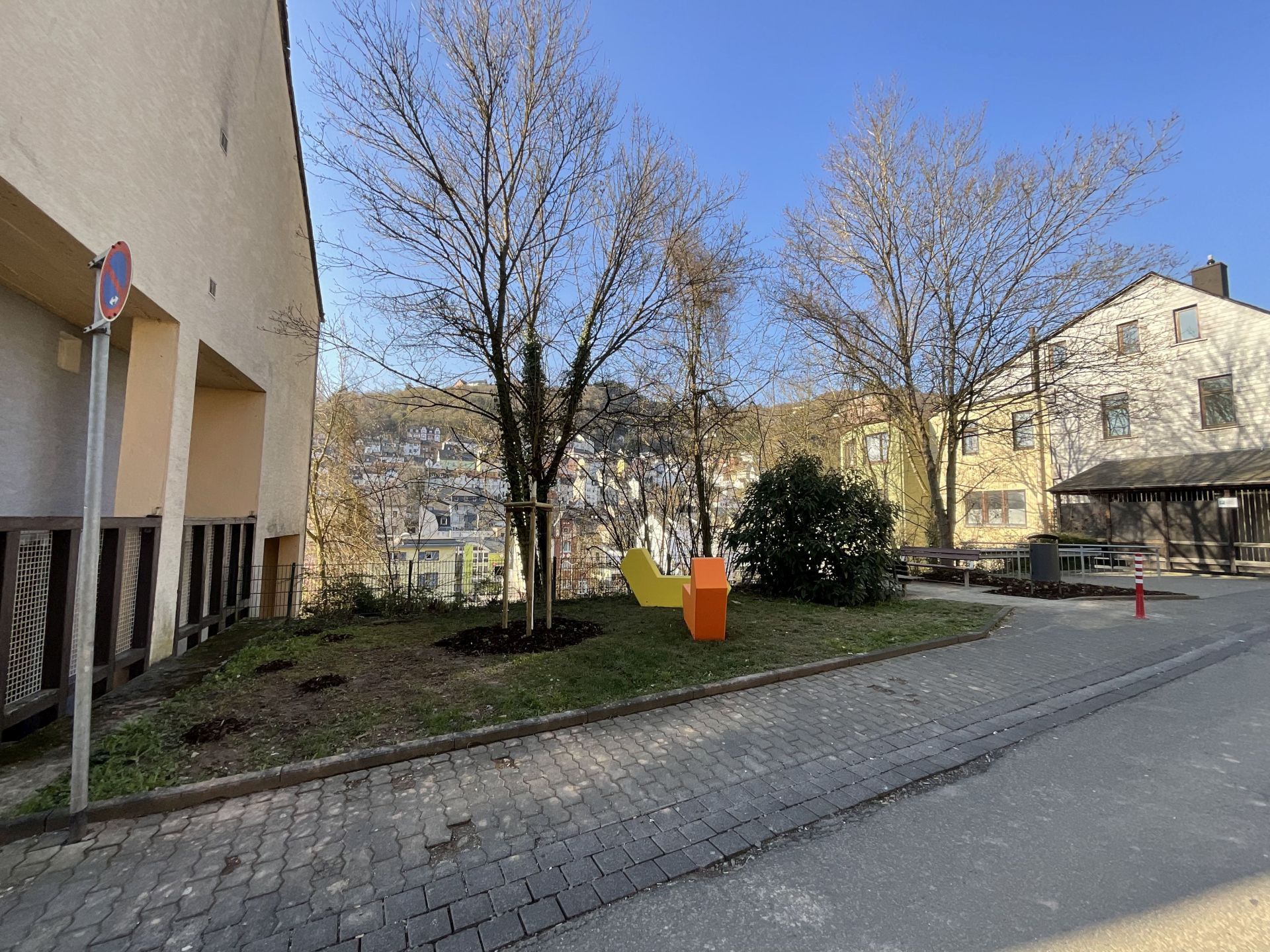 The photo shows the newly designed green area with two new seats in yellow and orange.