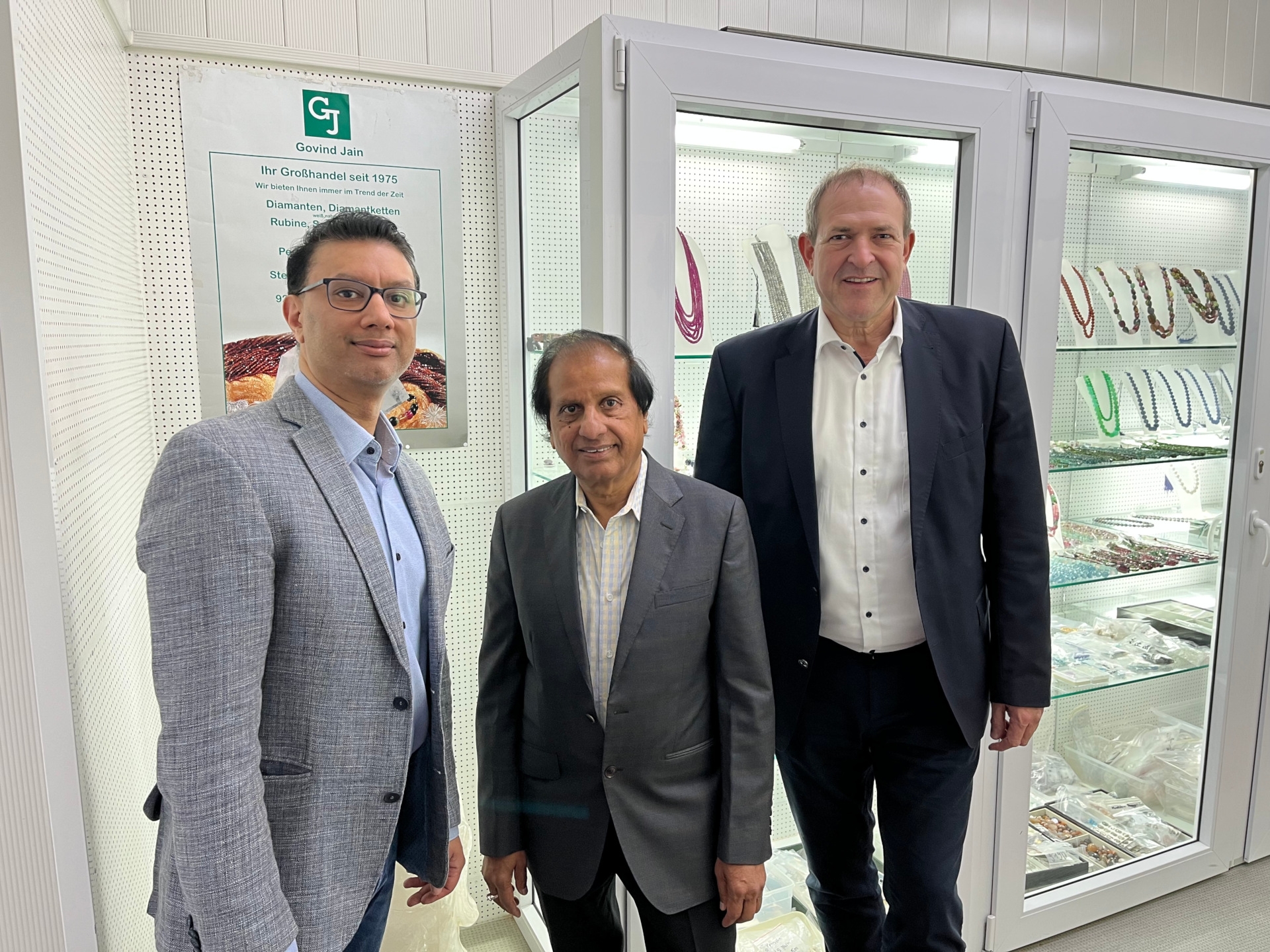 The photo shows the persons mentioned in front of display cases in the business premises.