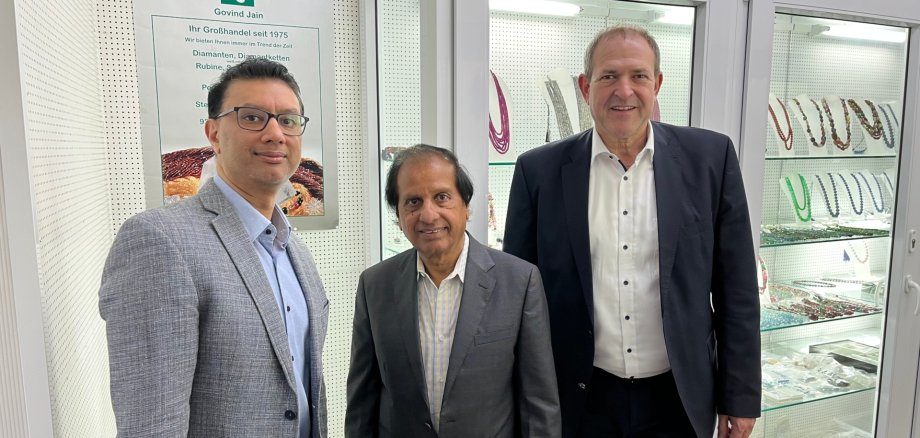 The photo shows the persons mentioned in front of display cases in the business premises.