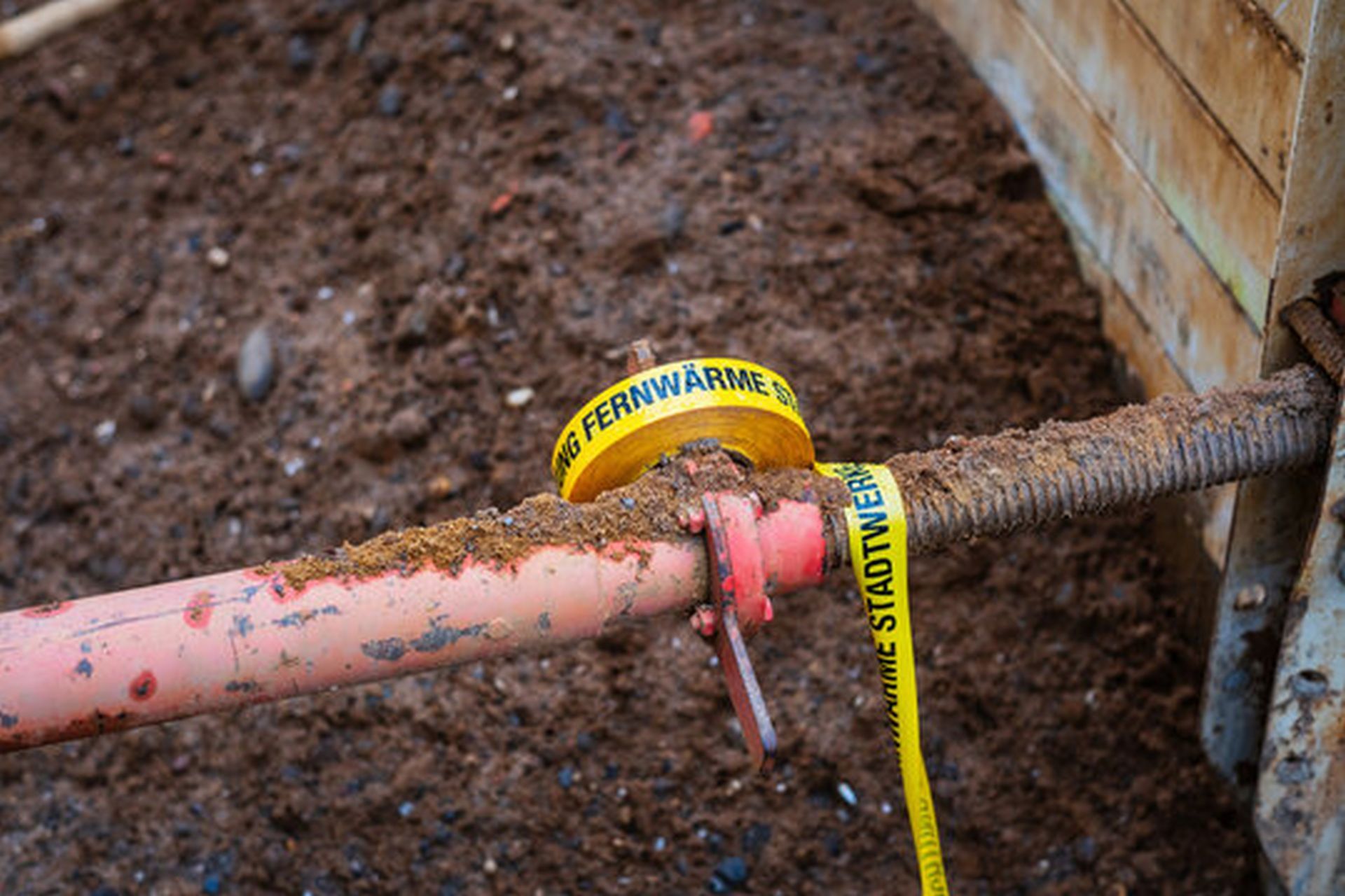 The photo shows a construction pit with a pipe, which is taken as a symbol for district heating.