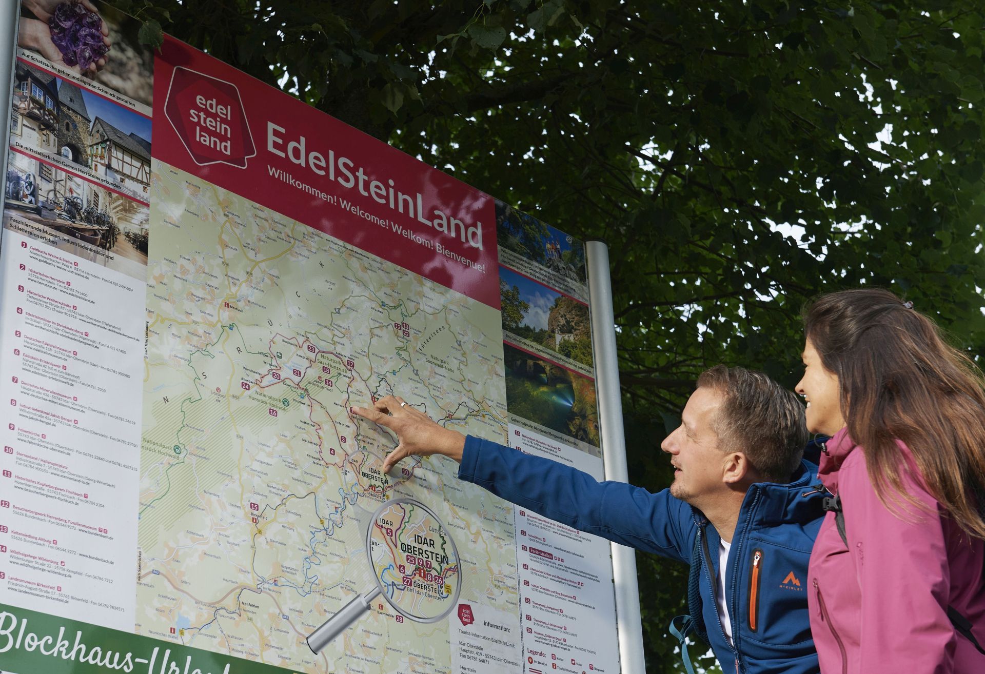 The photo shows two people standing in front of a map of the region. 