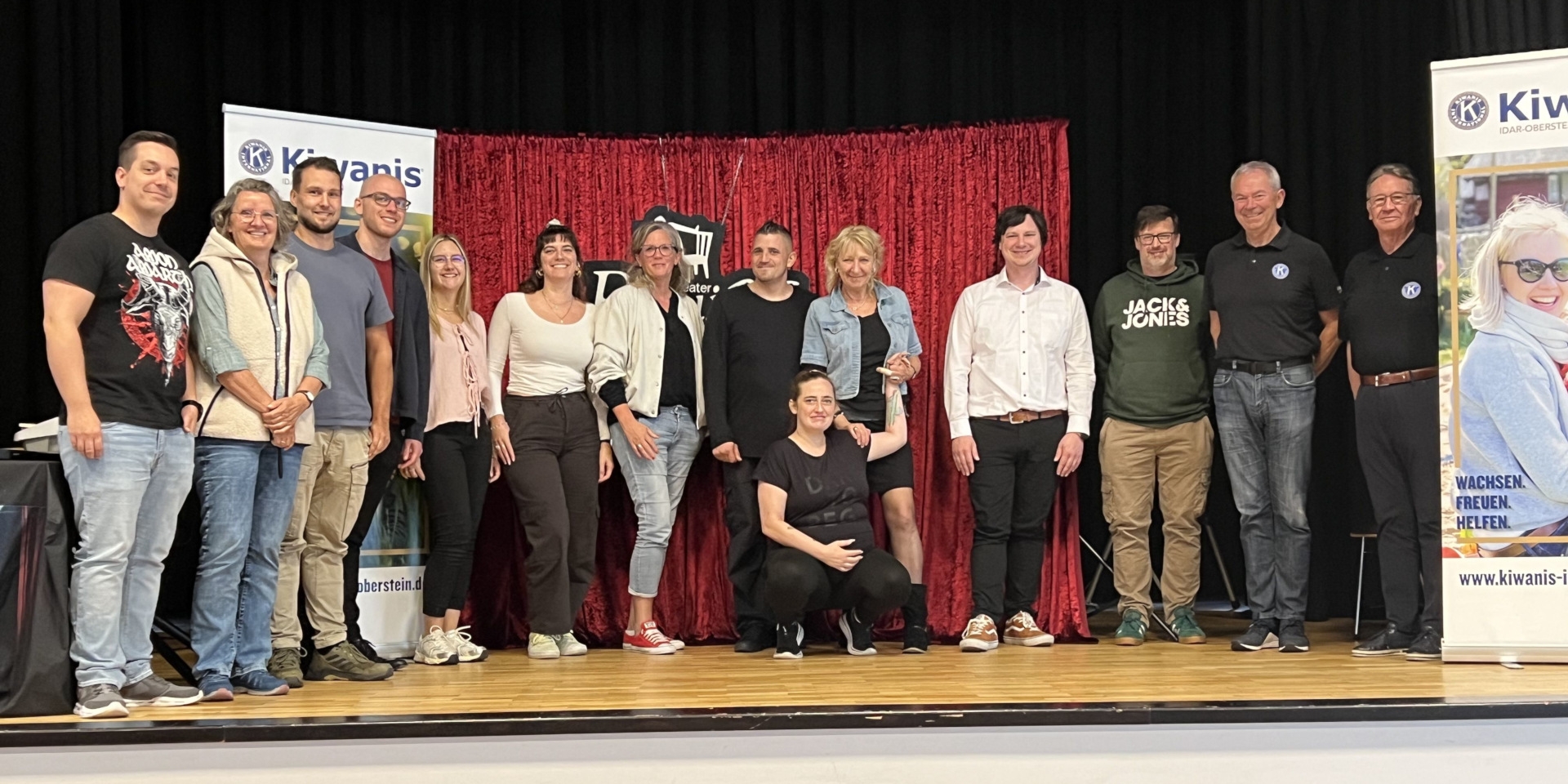 The photo shows the ensemble, as well as the event's organizers and supporters, on stage at the Göttenbach Auditorium.