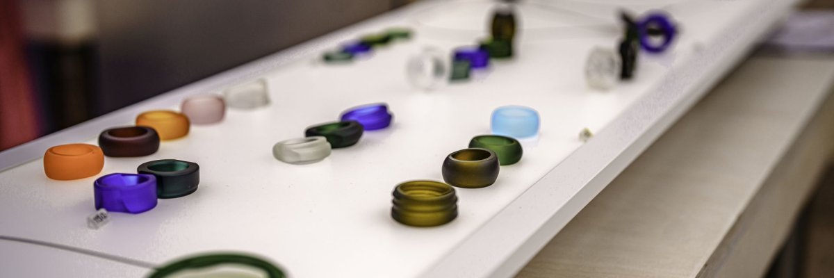 Bijoux en verre au marché des tailleurs de pierres précieuses et des orfèvres L'image montre des bagues et des colliers colorés fabriqués à partir de bouteilles de verre.