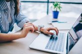 Image croisée de mains féminines recherchant des informations sur le web pendant le réseautage social via un ordinateur portable moderne, femme se connectant au wifi sans fil pour faire des réservations et des opérations bancaires en ligne sur un netbook Une main de femme pour un ordinateur portable