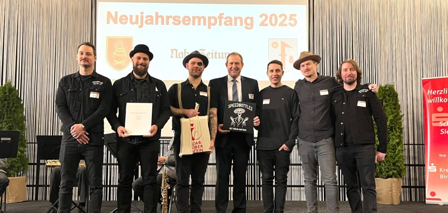 Lors de la réception du Nouvel An, le maire Frank Frühauf a décerné le prix culturel 2024 au groupe SpeedBottles. La photo montre les membres du groupe sur scène avec le maire Frühauf.