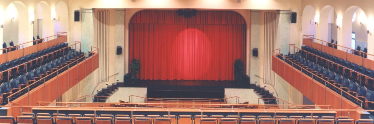 Le théâtre municipal d'Idar-Oberstein peut accueillir près de 600 personnes et dispose de sièges de théâtre et d'un bon équipement technique. L'image montre le théâtre municipal vide d'Idar-Oberstein avec les sièges du théâtre donnant sur la scène.