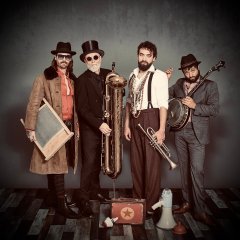 Photo du groupe de quatre musiciens. Avec des instruments étranges.