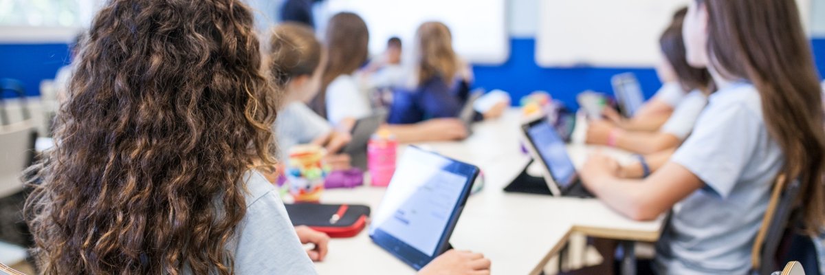 Les élèves sont assis dans la salle de classe et regardent le tableau.