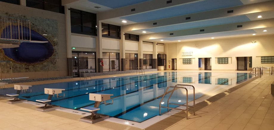 La photo montre le grand bassin de la piscine couverte.