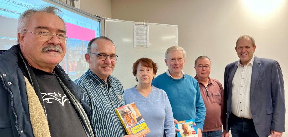 La photo montre les deux ambassadeurs du numérique, le maire Frühauf et trois participants à la réunion de consultation. Ils se tiennent côte à côte et regardent la caméra. Les ambassadeurs du numérique tiennent des brochures dans leurs mains.