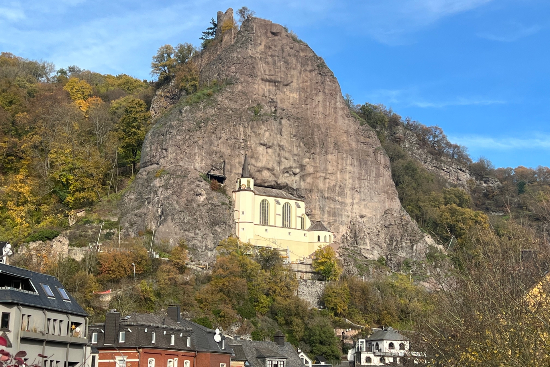 La photo montre l'église du rocher, située à environ 60 mètres au-dessus du fond de la vallée, dans une niche rocheuse.