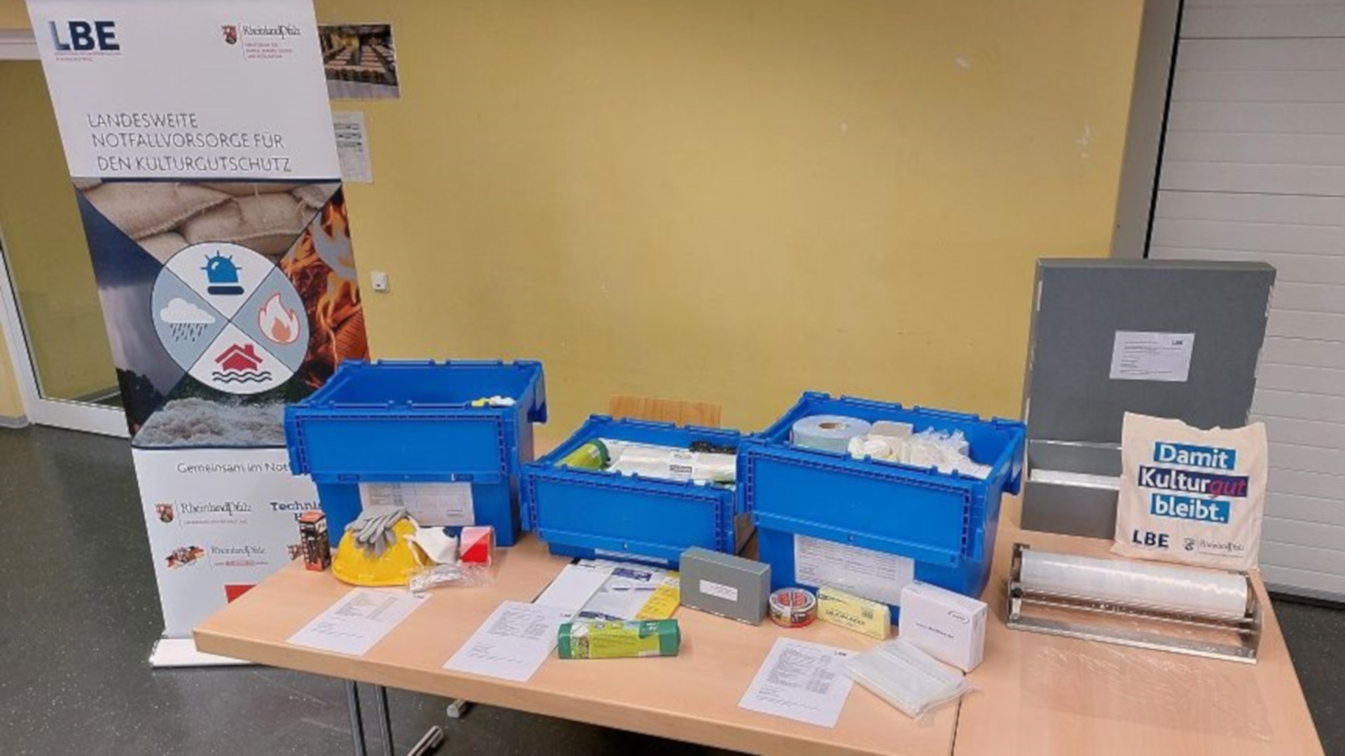 La photo montre une table sur laquelle sont posées les trois boîtes du kit d'urgence. Leur contenu respectif est étalé devant les boîtes.