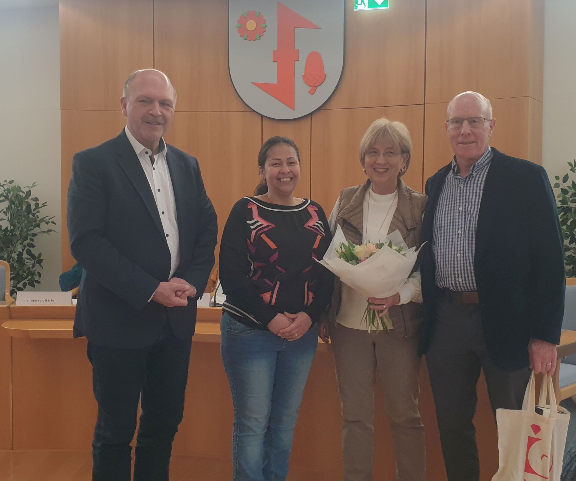 La photo montre le maire Friedrich Marx, Nancy Toro Botero, Jean et Delbert Penner dans la salle de réunion de la municipalité.