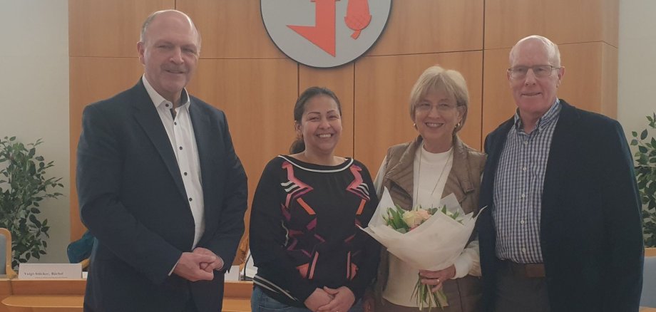 La photo montre le maire Friedrich Marx, Nancy Toro Botero, Jean et Delbert Penner dans la salle de réunion de la municipalité.