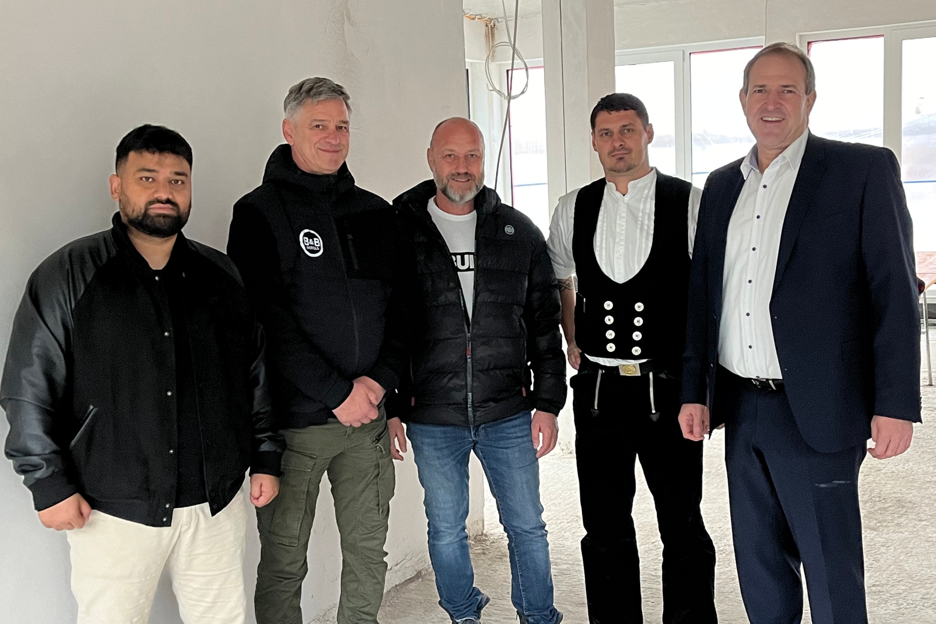 La photo montre les personnes mentionnées. Elles se tiennent côte à côte sur le chantier et regardent la caméra.