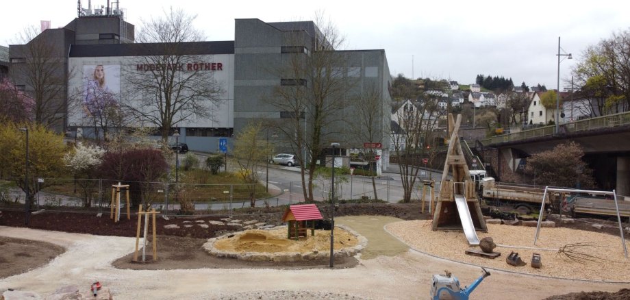 La photo montre l'aire de jeux pour enfants réaménagée sur la Helmut-Kohl-Europaplatz, avec de nouveaux équipements de jeux et une partie de la zone aquatique.