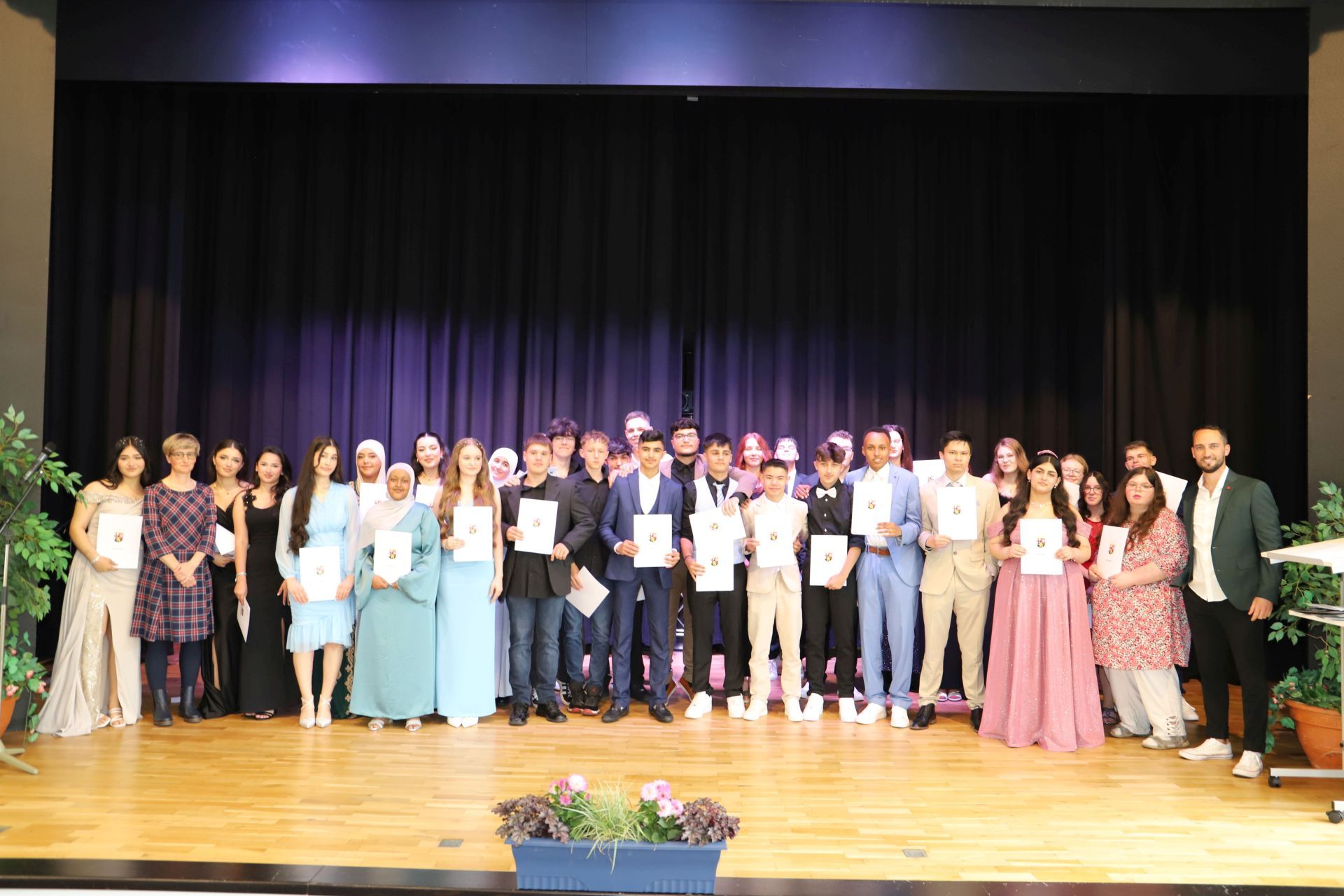 La photo montre les élèves sur la scène de la Göttenbach-Aula lors de la remise des diplômes.