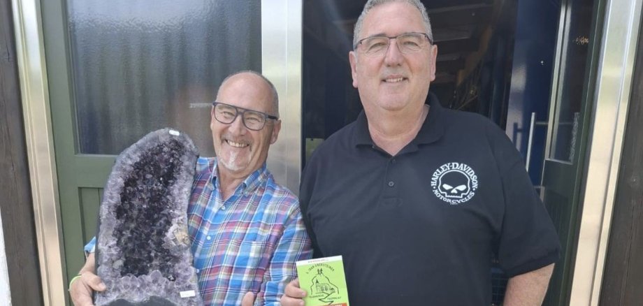 La photo montre Rainer Hagner et Jörg Welsch avec la bombe d'améthyste pour la tombola de la course des escaliers.