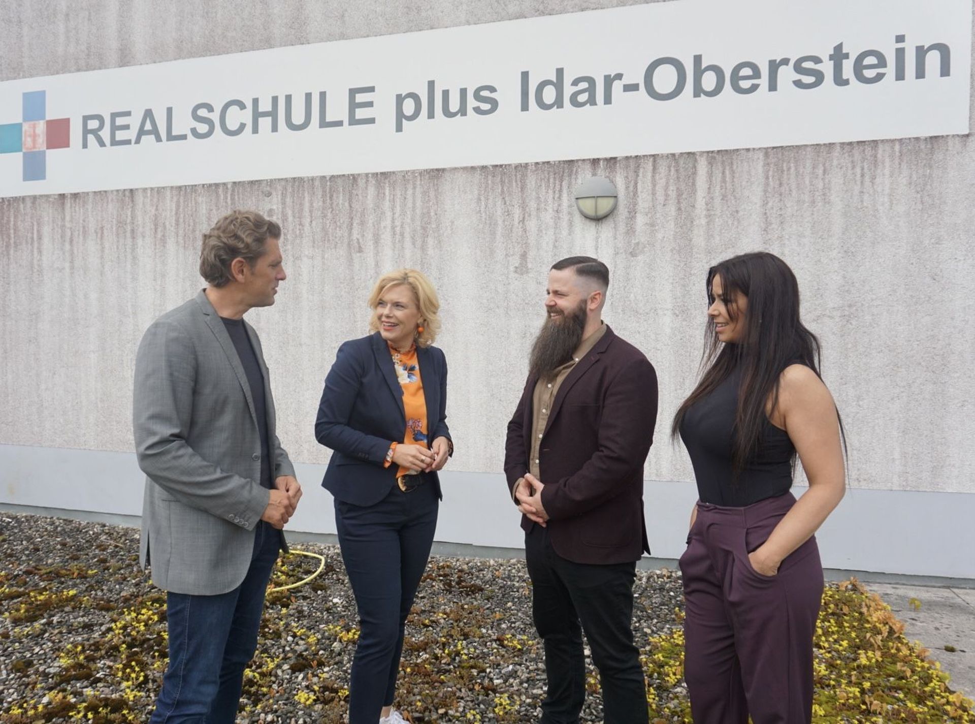 La photo montre la députée Julia Klöckner, le député Marlon Bröhr, le directeur de l'école Christian Back et la directrice adjointe Julia Molter lors d'une visite du Realschule Plus à Idar-Oberstein.  