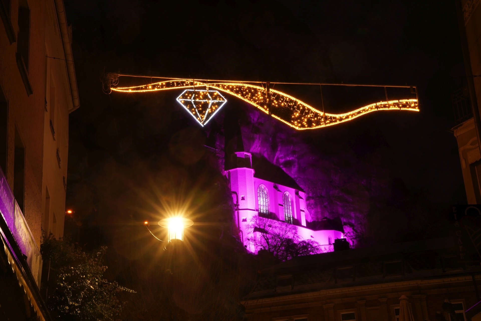 La photo montre l'église du Rocher illuminée en couleur.