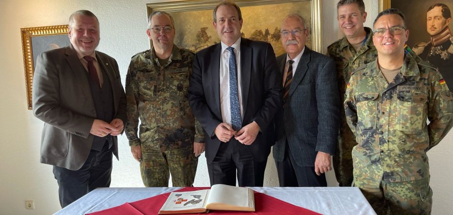 La photo montre les acteurs lors de la signature du livre d'or de la ville par l'inspecteur de l'armée de terre lors de sa visite à l'école d'artillerie.