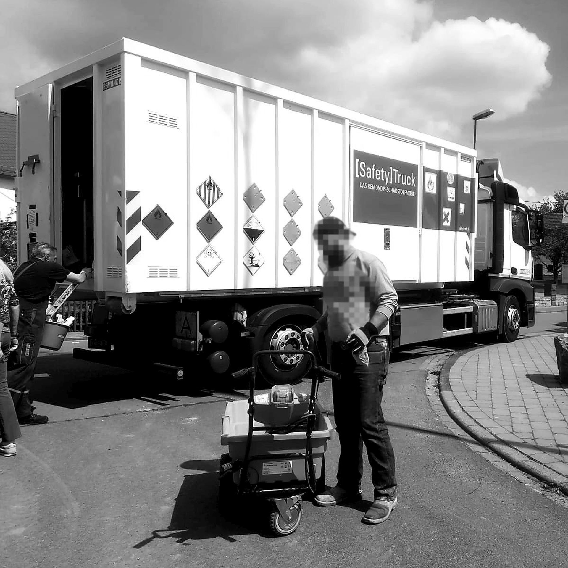 La photo montre un camion qui collecte des polluants avec un employé devant.