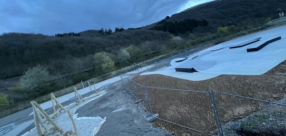 L'image montre la piste de skate et une structure d'escalade dans le nouveau parc urbain