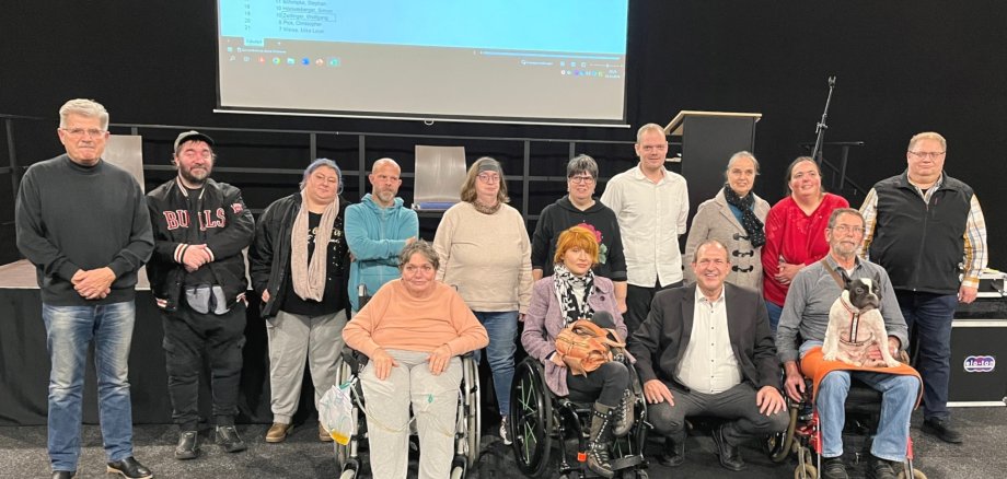 La photo montre le maire et les 13 membres du conseil consultatif. Dix personnes se trouvent dans la rangée du fond, trois personnes en fauteuil roulant se trouvent dans la rangée de devant. Entre elles, le maire Frühauf est agenouillé.