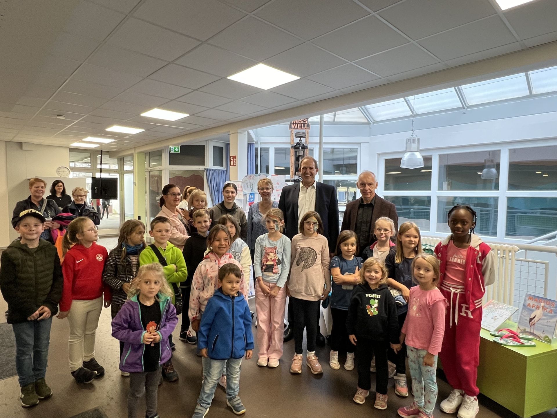 Le maire Frank Frühauf, la directrice de la bibliothèque Sandra Ley et l'employé de la KSK Leonhard Stibitz entourés d'enfants et d'adolescents venus chercher leurs diplômes.