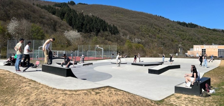 La photo montre des personnes sur le skatepark du parc municipal.