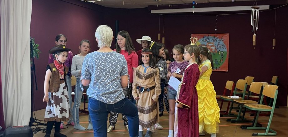 La photo montre les enfants participants sur scène lors d'une réunion avec Kerstin Kornetzky.
