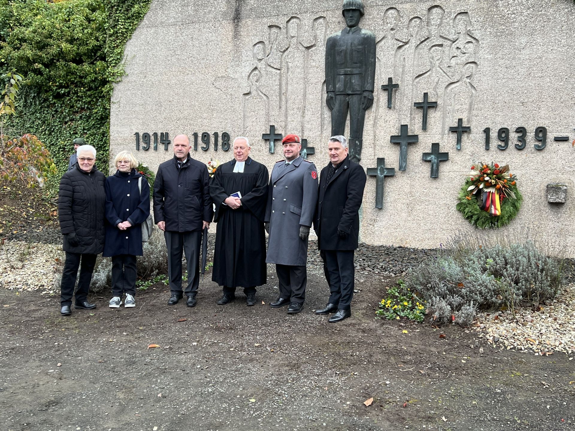La photo montre les participants à la journée de deuil national devant le monument aux morts de Niederau.