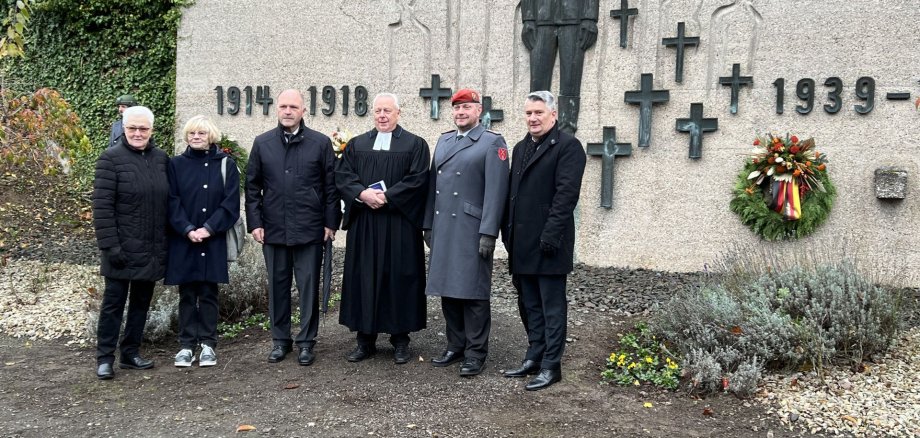 La photo montre les participants à la journée de deuil national devant le monument aux morts de Niederau.