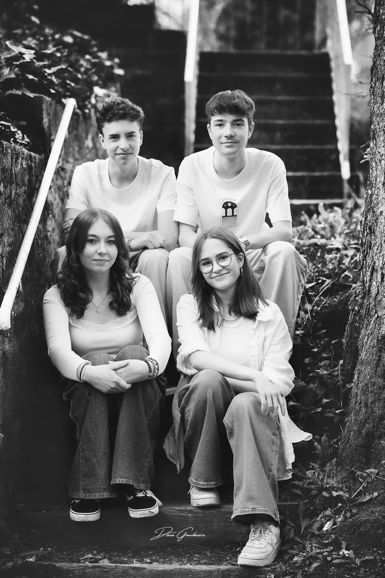 La photo montre les quatre membres du groupe assis sur un escalier.