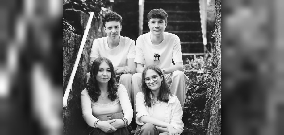 Le groupe Twenty2s joue à la fête de Noël au JAM. La photo montre les quatre membres du groupe assis sur un escalier.