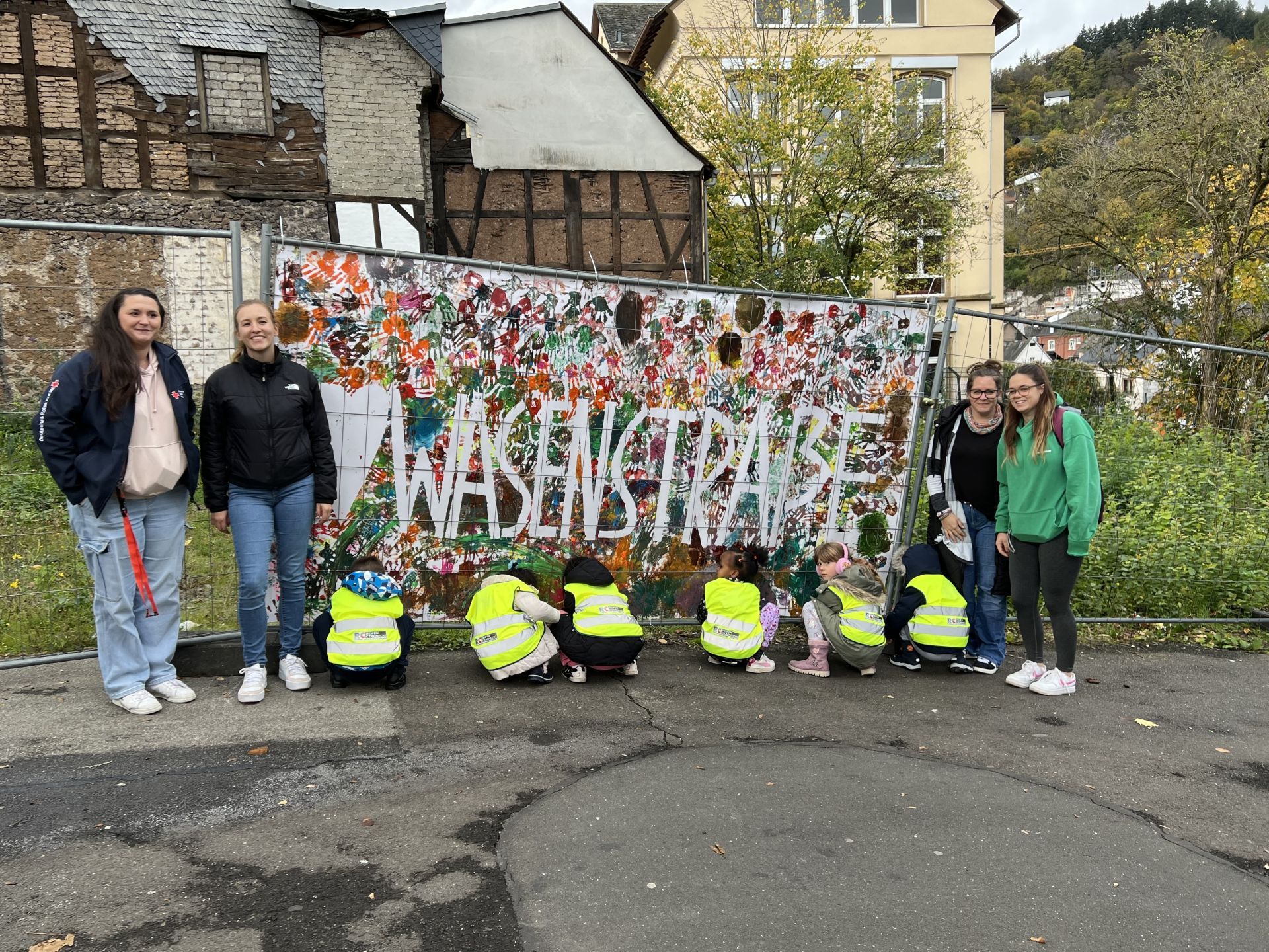 Walburga, Natalie Kee et Emelie Fraunholz de la crèche St. Walburga accrochent la bannière avec les enfants de la crèche.