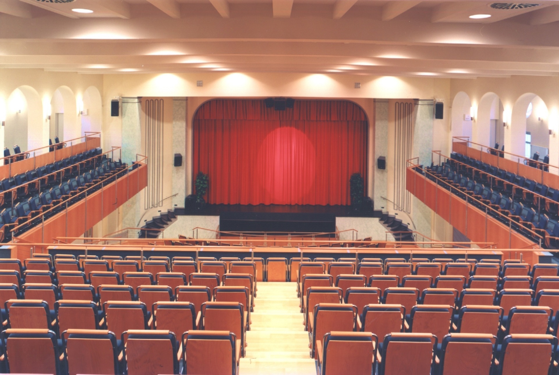 La photo montre une vue de la scène du théâtre municipal depuis les gradins. Le rideau de la scène est fermé.