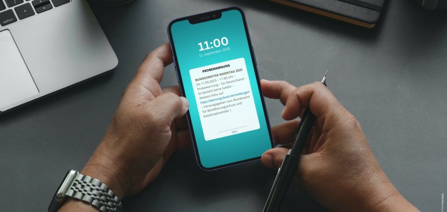 La photo montre un téléphone mobile sur lequel un message d'avertissement est affiché.