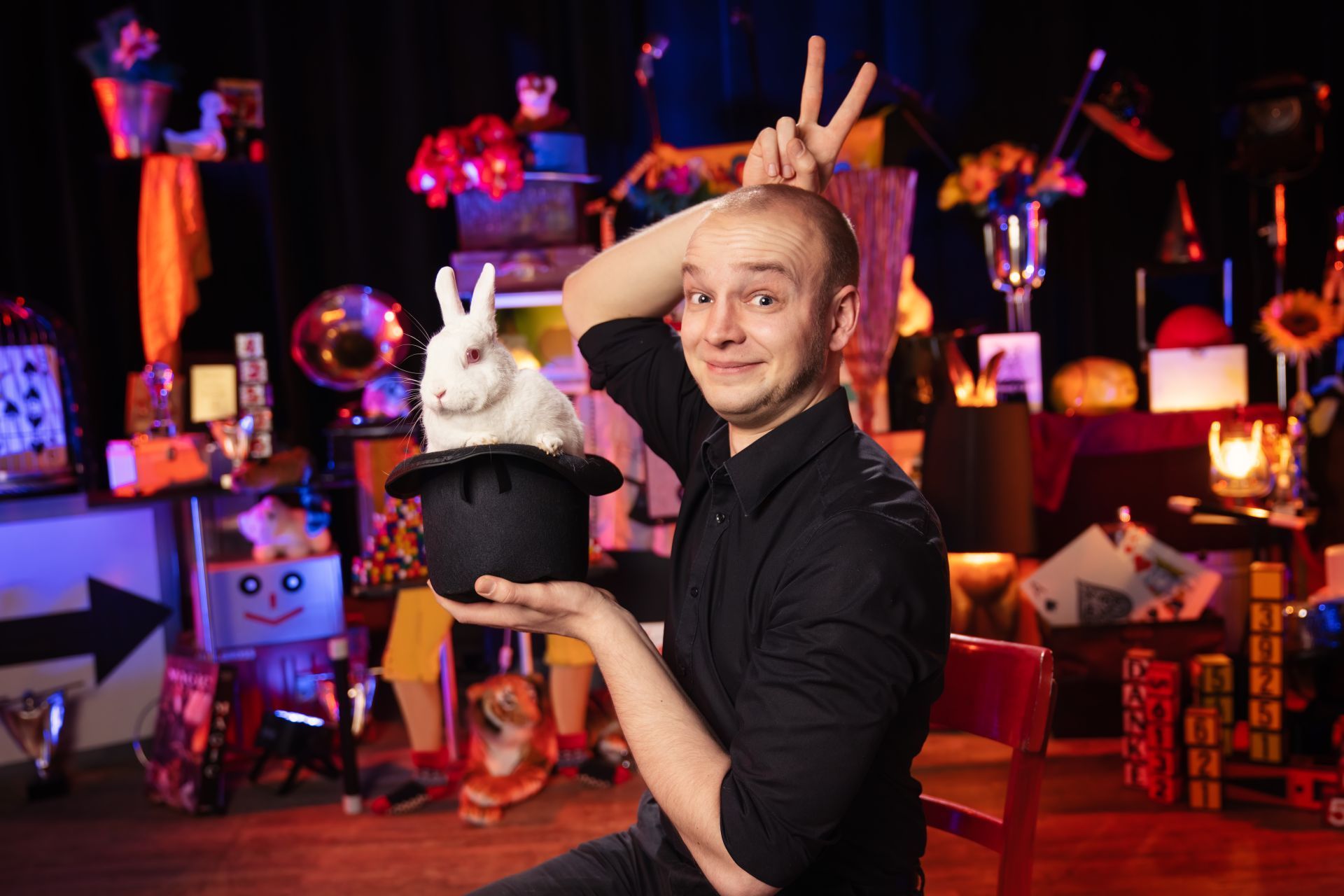 La photo montre le magicien Jakob Mathias avec un chapeau de magicien dans lequel se trouve un lapin blanc.