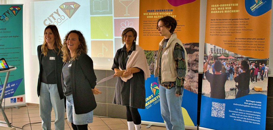 La photo montre les personnes mentionnées devant des roll-ups contenant des informations sur le programme de subvention.