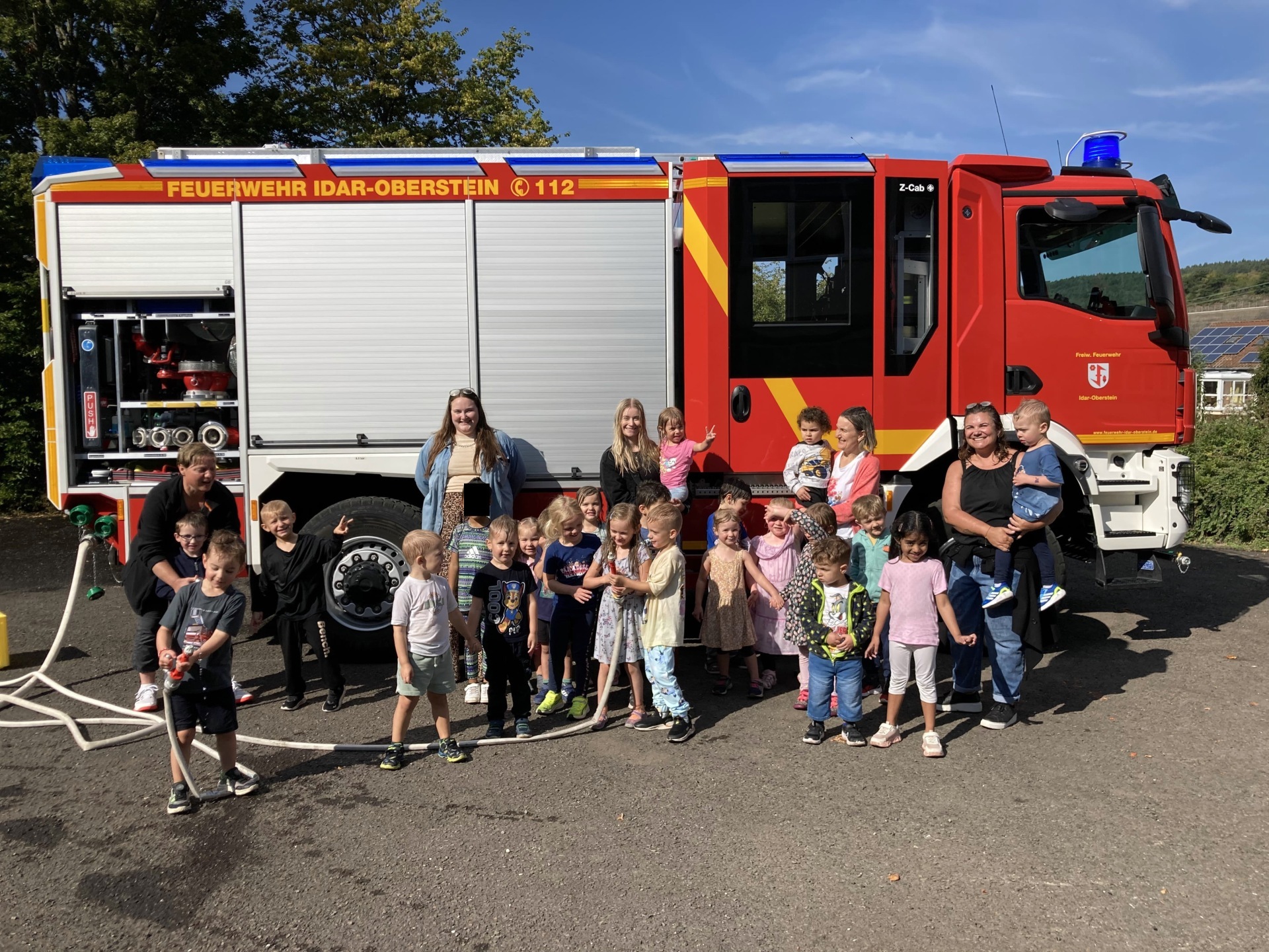 La photo montre les enfants et les éducateurs devant le camion de pompiers.