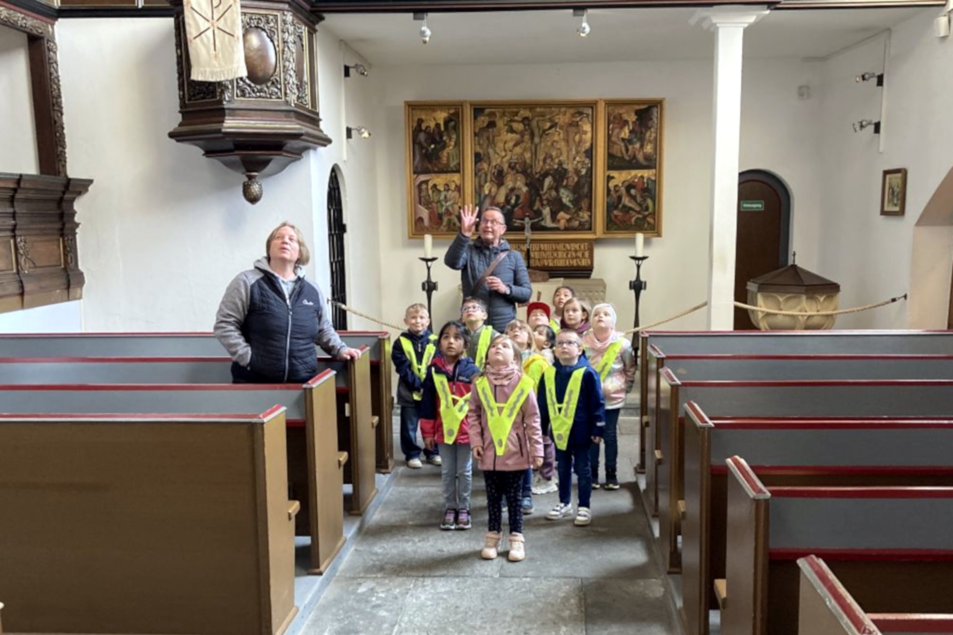 La photo montre le groupe en train de faire la visite, les enfants regardant le plafond avec fascination.