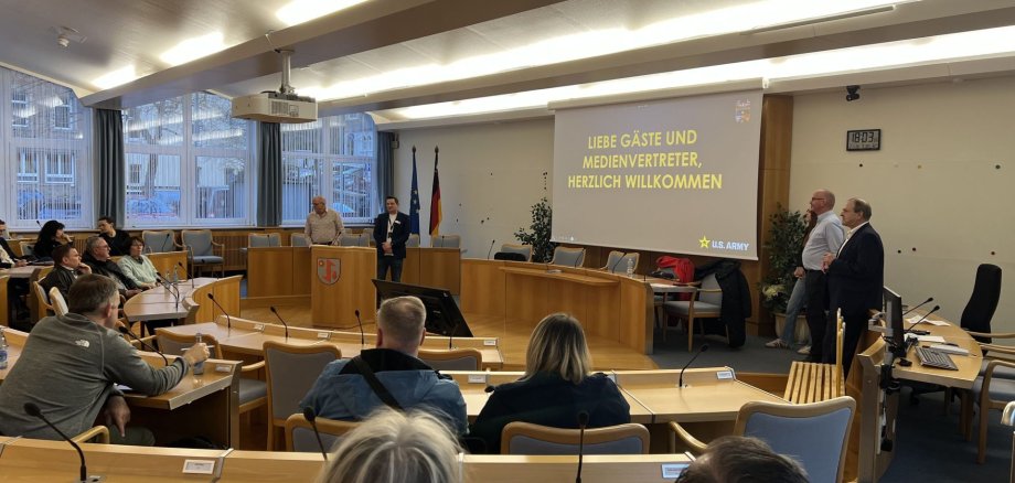 La photo montre de nombreux propriétaires immobiliers intéressés dans la salle de réunion, qui s'informent sur les locations aux soldats américains.
