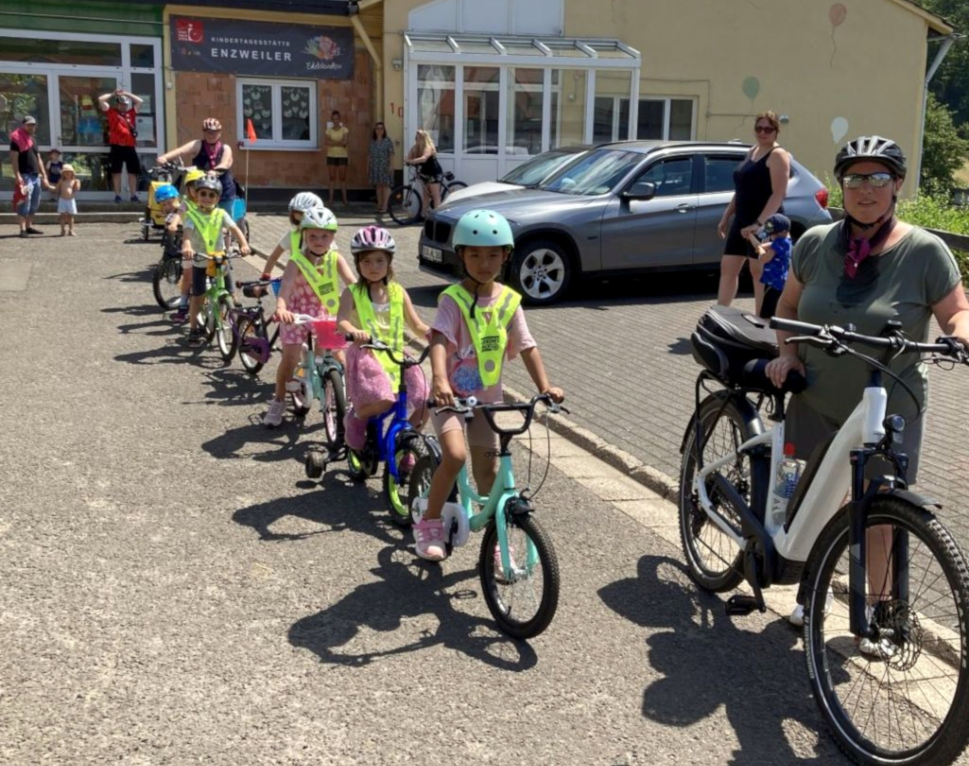 La photo montre les enfants devant la crèche avec leurs vélos.