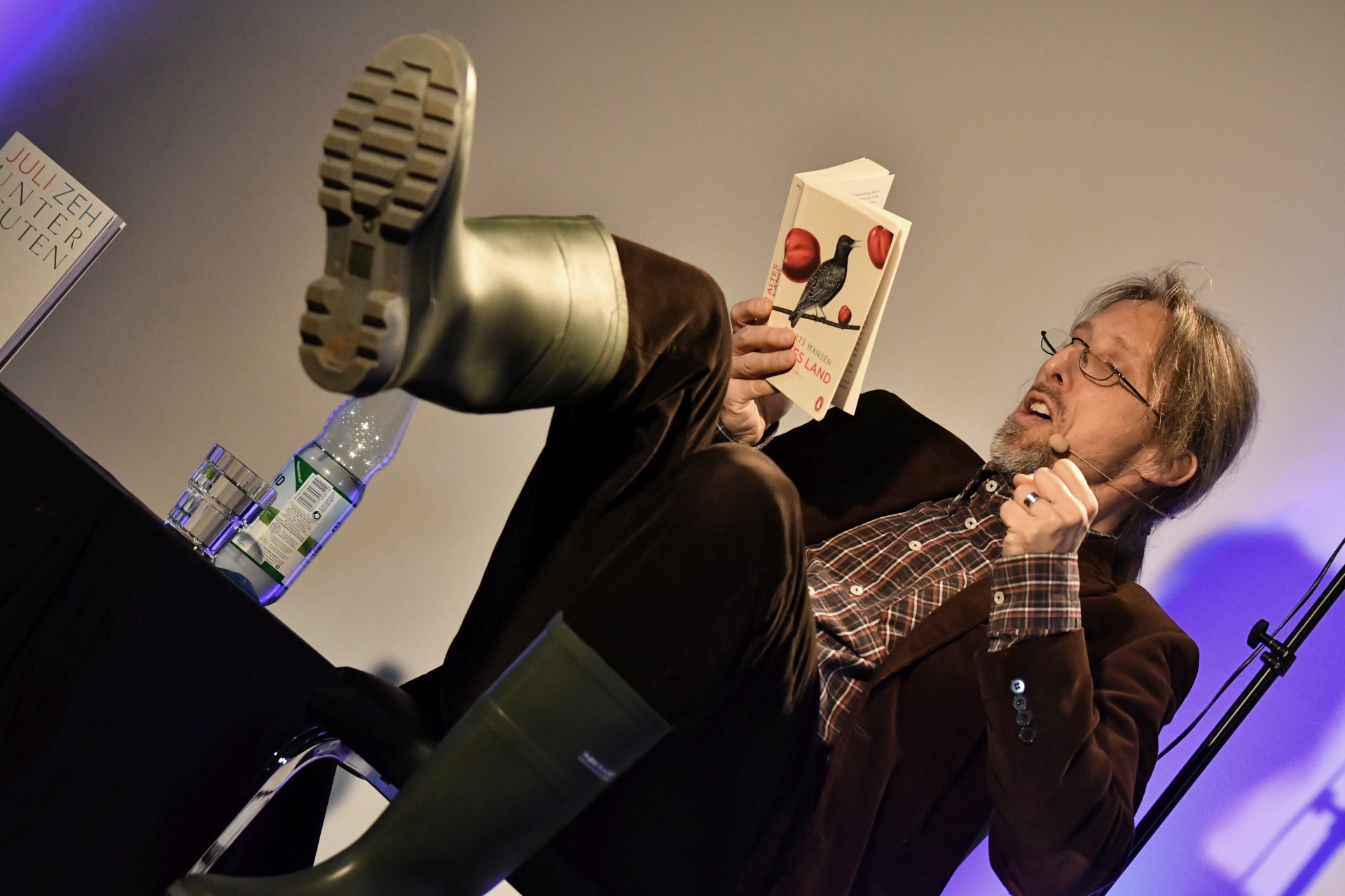 La photo montre Rainer Rudloff lors d'une lecture.